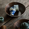 Single hand-painted blue and white teacup with silver rim, featuring a mountain and river scene.