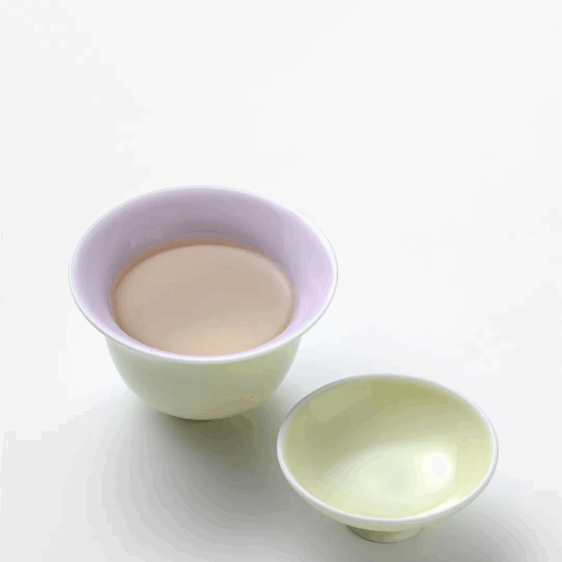 Pouring tea from 90ml dual-color gaiwan (yellow exterior, pink-purple interior) into 45ml cup