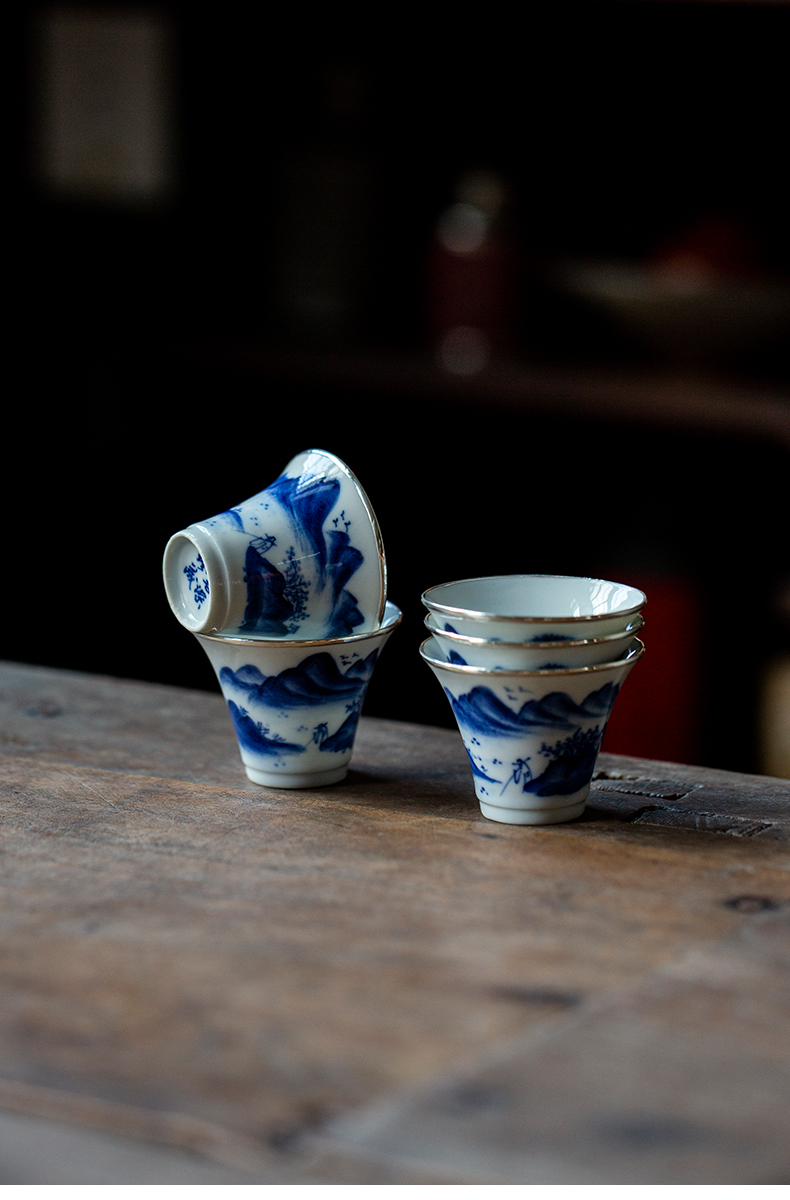 Collection of porcelain teacups with hand-painted blue and white designs from different angles.