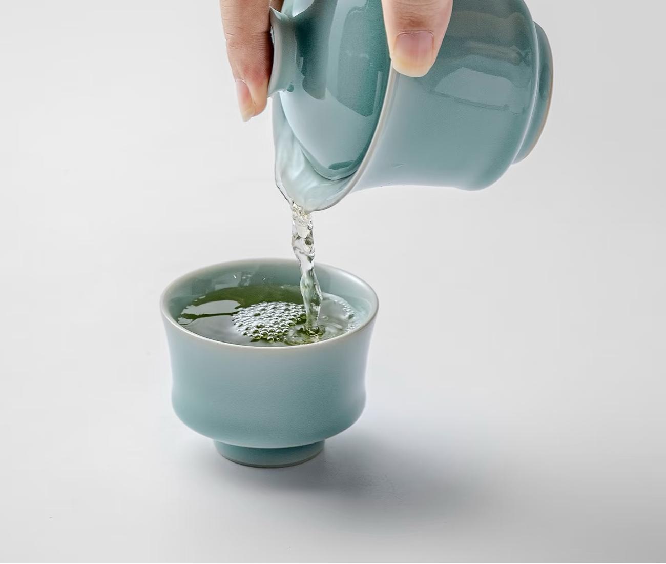 cd51c8e00ec5a075f8e3606d5548507c Pouring green tea from 110ml powder blue gaiwan into 70ml horseshoe cup